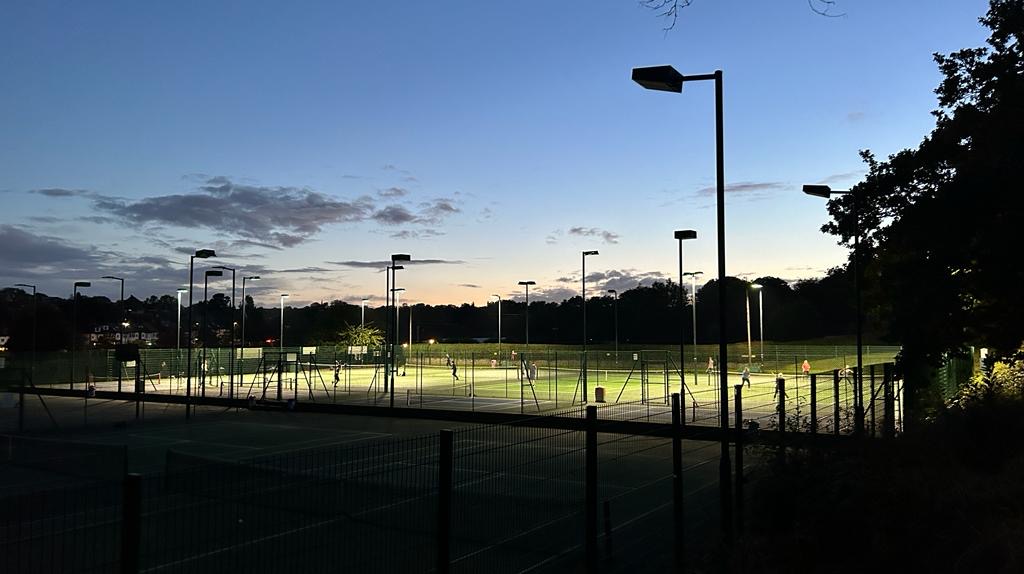 Floodlit tennis courts beside the pavilion café terrace